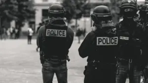Agents de police en uniforme patrouillant dans une rue urbaine en France.
