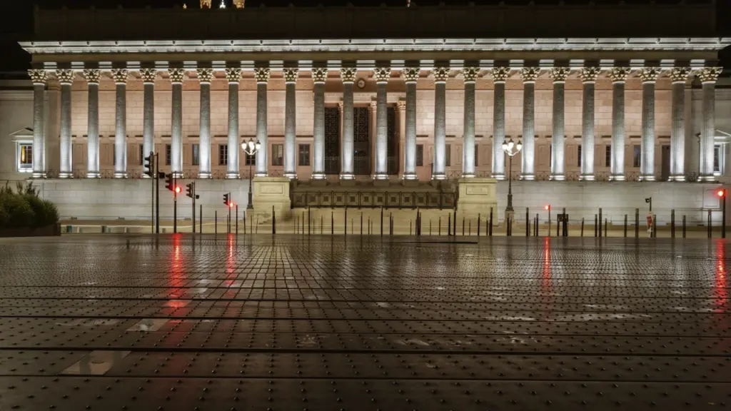 La façade illuminée du Palais de Justice de Lyon la nuit.