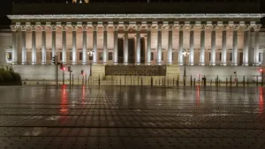 La façade illuminée du Palais de Justice de Lyon la nuit.