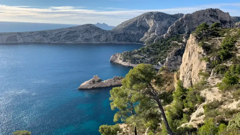 Vue aérienne des calanques de Marseille avec rochers escarpés et mer turquoise.