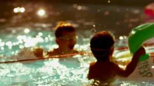 Deux jeunes enfants jouent et apprennent la sécurité dans une piscine ensoleillée.