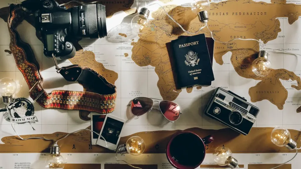Un passeport et un appareil photo posés sur une carte du monde ancienne.