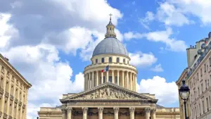 Le dôme iconique du Panthéon à Paris sous un ciel bleu partiellement nuageux.