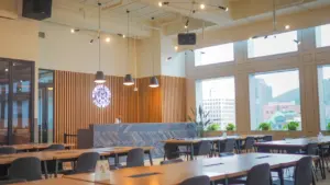 Une salle à manger moderne et lumineuse aménagée comme un espace de restauration scolaire.