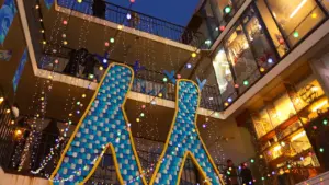 Décorations lumineuses colorées dans une cour urbaine lors d'une soirée estivale festive.