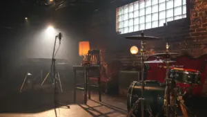 Une scène de concert avec des instruments et des éclairages tamisés dans une salle.
