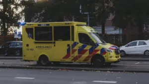 Une ambulance jaune circulant dans une rue urbaine pour une urgence médicale.