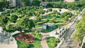 Vue aérienne d'un parc urbain verdoyant avec des allées et des espaces de jeux.