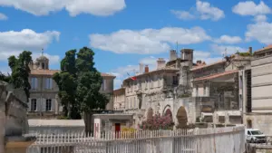 Vue architecturale historique des bâtiments anciens sous un ciel bleu à Arles.