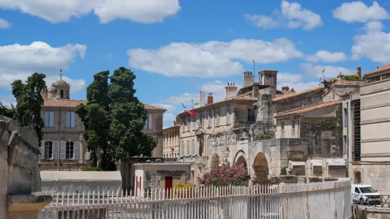 Vue architecturale historique des bâtiments anciens sous un ciel bleu à Arles.