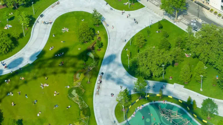 Vue aérienne d'un parc urbain avec des espaces verts et des jeux d'enfants.