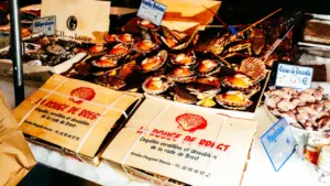 Plateaux de coquilles Saint-Jacques fraîches sur l'étal d'un marché à Brest.