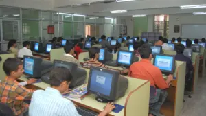 Une salle informatique universitaire avec des étudiants travaillant sur des ordinateurs de bureau.