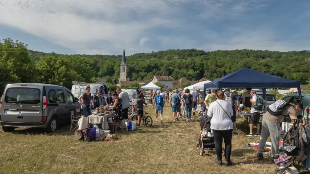 Un marché traditionnel et convivial en plein air dans un village français en été.