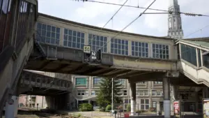 Une passerelle moderne surplombant des voies ferrées dans une gare urbaine française.