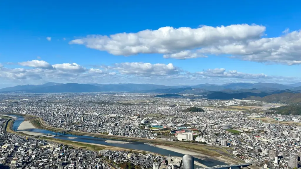 Vue panoramique d'une ville avec une rivière sous un ciel bleu dégagé.