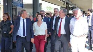 Un groupe de personnalités politiques marchant sur le quai d'une gare ferroviaire à Lyon.
