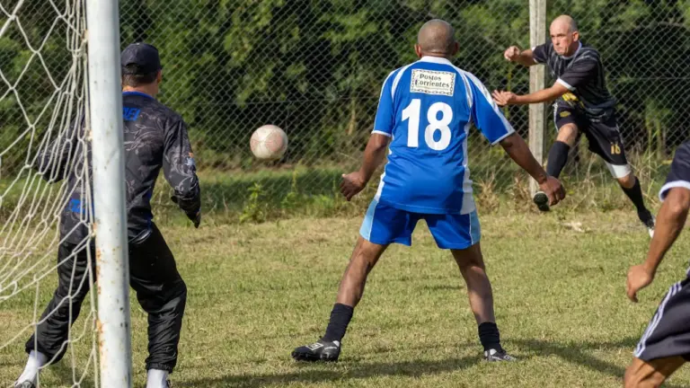 Joueurs de football amateur en pleine action sur le terrain lors d'un match.