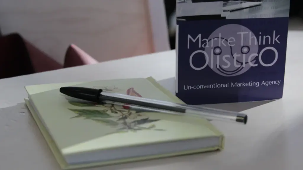 Un stylo noir posé sur un livre fermé sur une table de travail.