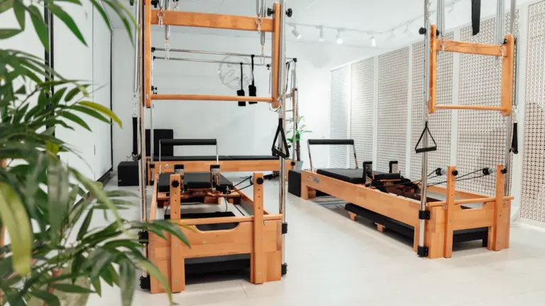 Salle de sport lumineuse avec des équipements professionnels de Pilates en bois.