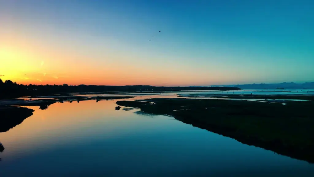Coucher de soleil paisible sur une rivière reflétant les couleurs du crépuscule en été.