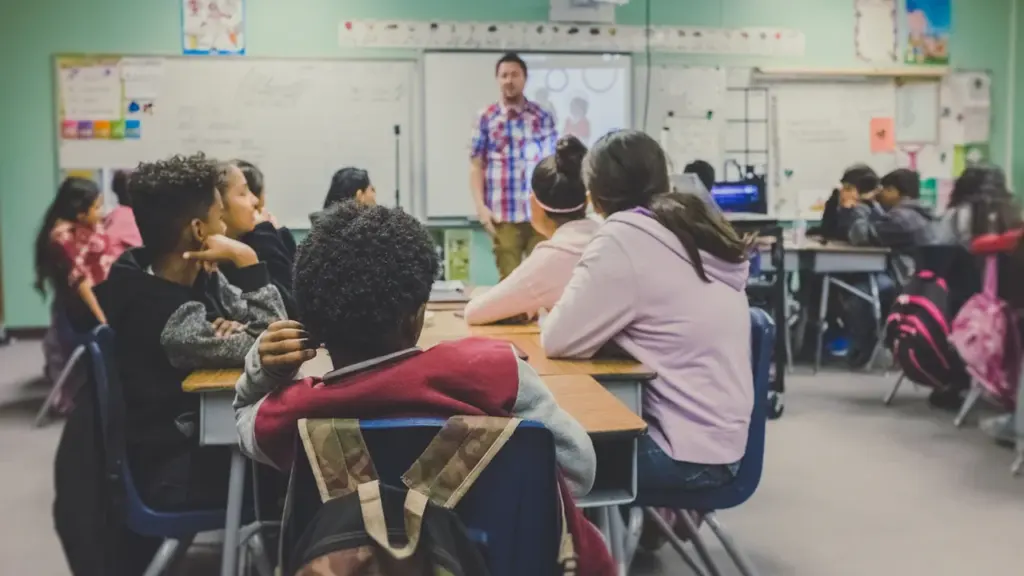 Une salle de classe dynamique avec un enseignant s'adressant à ses jeunes élèves attentifs.