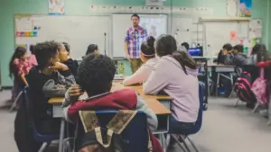 Une salle de classe dynamique avec un enseignant s'adressant à ses jeunes élèves attentifs.