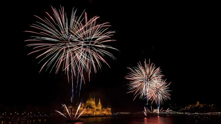 Feu d'artifice tiré au-dessus d'un plan d'eau calme près d'un temple.