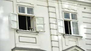 Fenêtres ouvertes sur la façade d'un bâtiment blanc lors d'une journée ensoleillée.