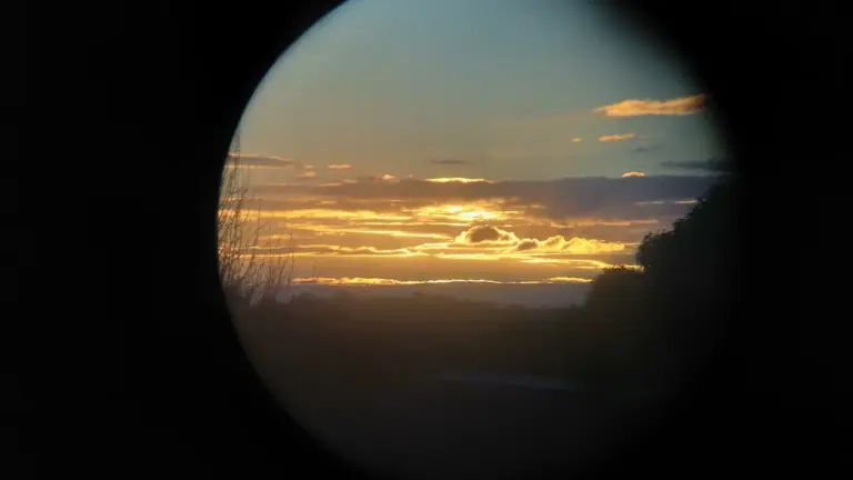 Vue circulaire sur un coucher de soleil doré à travers une lentille de télescope.
