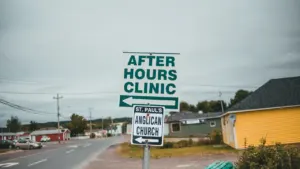 Panneau de signalisation routière indiquant une clinique de garde et une église.
