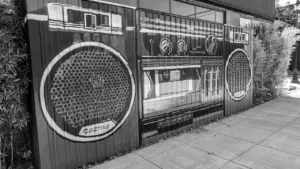 Murale artistique représentant une radio rétro sur un mur urbain extérieur.