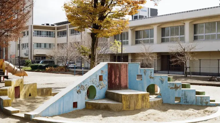 Structure de jeux colorée installée au milieu d'une cour d'école en extérieur.