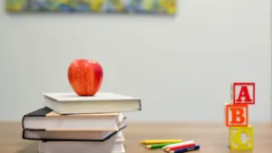 Une pomme rouge sur des livres avec des crayons de couleur et blocs alphabet.