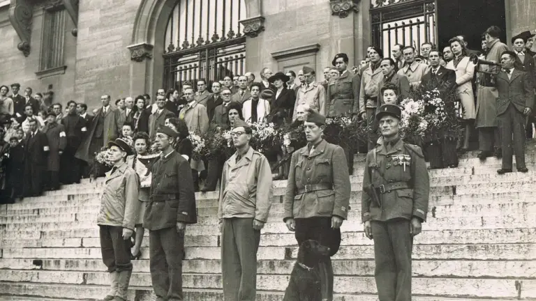 Un groupe de soldats et civils en uniforme alignés sur les marches d'un édifice public.