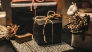 Plusieurs boîtes cadeaux élégantes disposées sur un textile à motifs floraux.