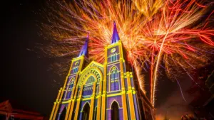 Feu d'artifice spectaculaire illuminant une église historique lors d'une fête locale en soirée.