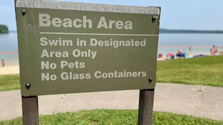Panneau d'information sur une plage, avertissant sur les règles de baignade en vigueur.