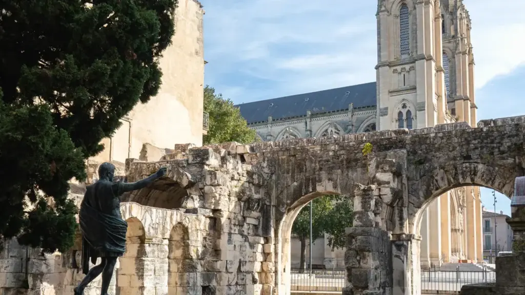 Statue d'un homme romain devant les vestiges d'une ancienne église aux flèches gothiques
