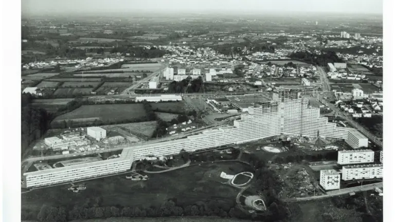 Vue aérienne en noir et blanc d'un immense complexe résidentiel en forme de V.