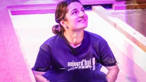 Une femme souriante participant à une séance de relaxation dans un espace lumineux.