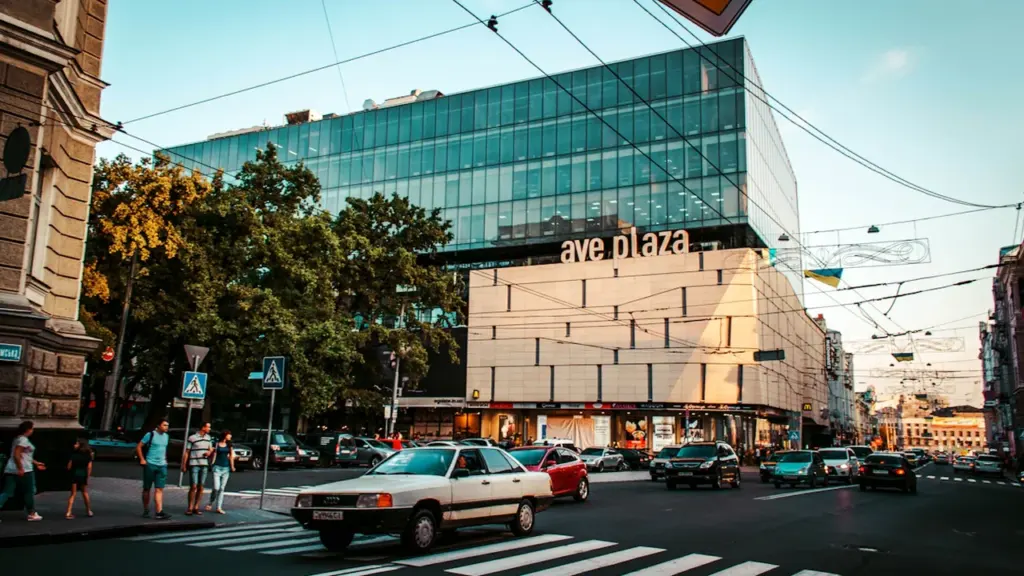 Une rue animée avec un centre commercial moderne au cœur d'une ville dynamique.