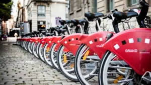 Alignement de vélos en libre-service rouges sur une station urbaine en France.
