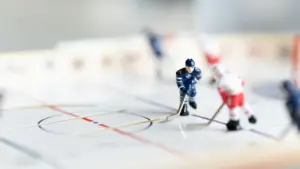 Figurines de joueurs de hockey sur une patinoire miniature pour illustrer le sport.