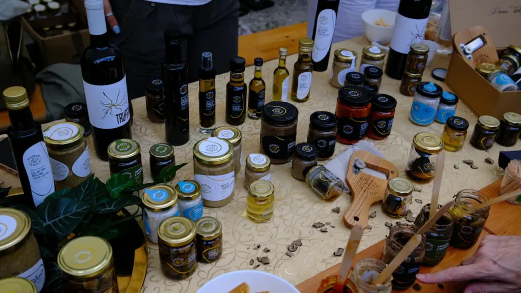 Une sélection variée de produits artisanaux, huiles et vins sur une table en bois.