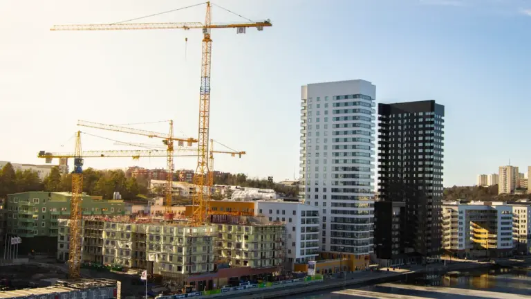 Vue aérienne d'un chantier de construction urbain avec des grues et des immeubles.