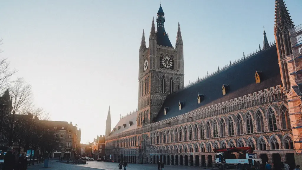 Vue architecturale d'un bâtiment historique français avec une tour horloge au coucher du soleil.