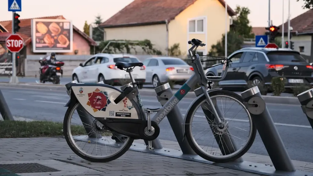 Un vélo de location stationné dans une rue calme en fin de journée.